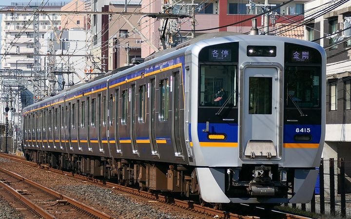 南海電鐵的白色電車,車身有藍色與橘色的條紋