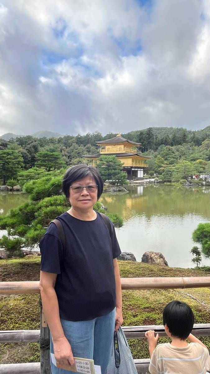 媽媽站在池邊，後方是金閣寺